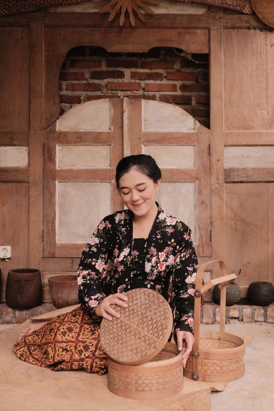 Pengunjung duduk di beranda rumah kayu tradisional, Dusun Deliek